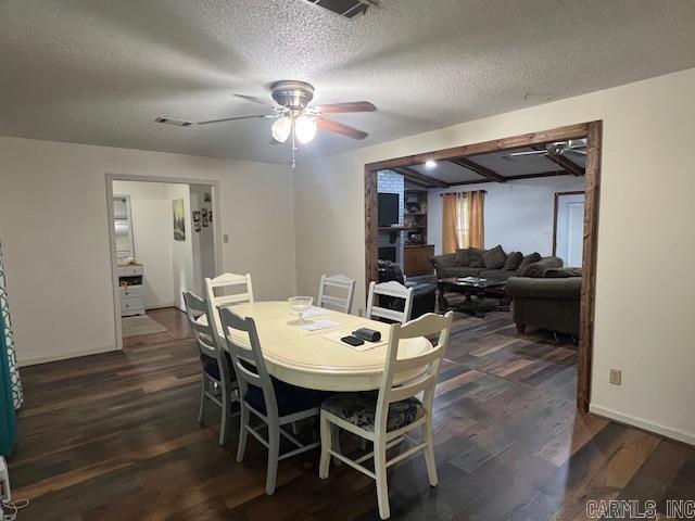 dining room featuring ceiling fan, dark hardwood / wood-style flooring, and a textured ceiling