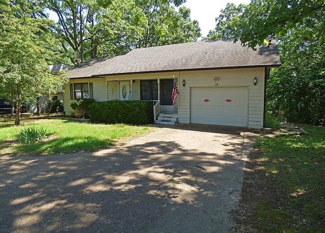 ranch-style house featuring a garage and a front lawn