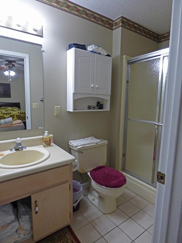 bathroom featuring ceiling fan, walk in shower, tile patterned flooring, a textured ceiling, and vanity