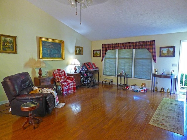 miscellaneous room featuring ceiling fan, wood-type flooring, lofted ceiling, and a textured ceiling