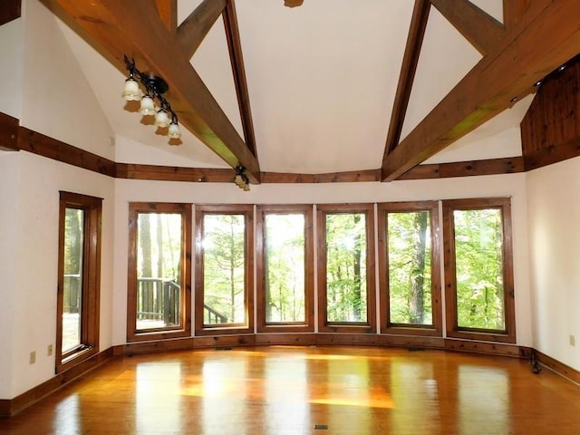 unfurnished sunroom featuring lofted ceiling with beams