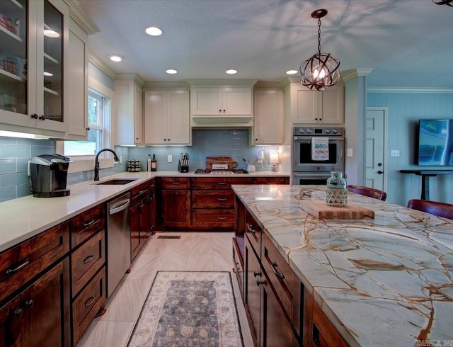 kitchen with dark brown cabinetry, sink, hanging light fixtures, and stainless steel appliances