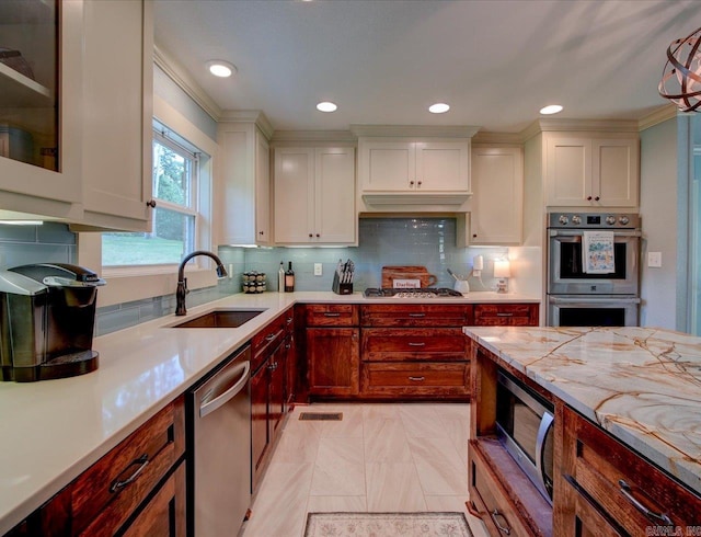 kitchen with tasteful backsplash, sink, light tile patterned floors, and stainless steel appliances