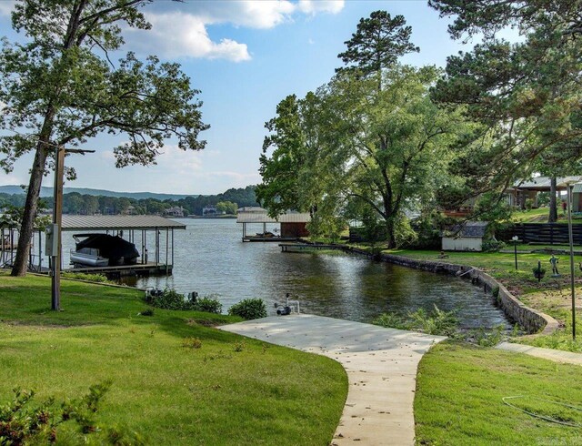 dock area with a lawn and a water view