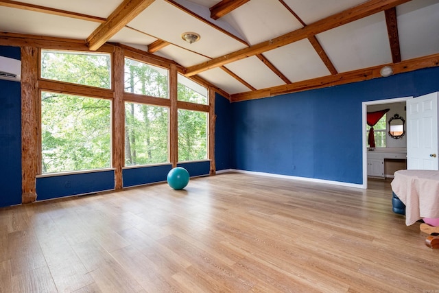 interior space featuring a wealth of natural light, lofted ceiling with beams, and hardwood / wood-style floors