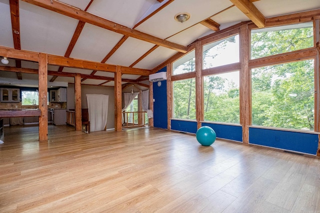 interior space featuring high vaulted ceiling, beam ceiling, light hardwood / wood-style floors, and a wall mounted air conditioner