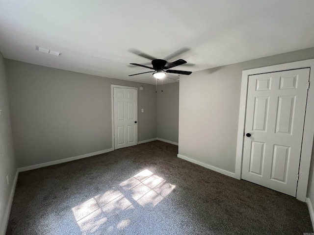 unfurnished bedroom with dark colored carpet and ceiling fan