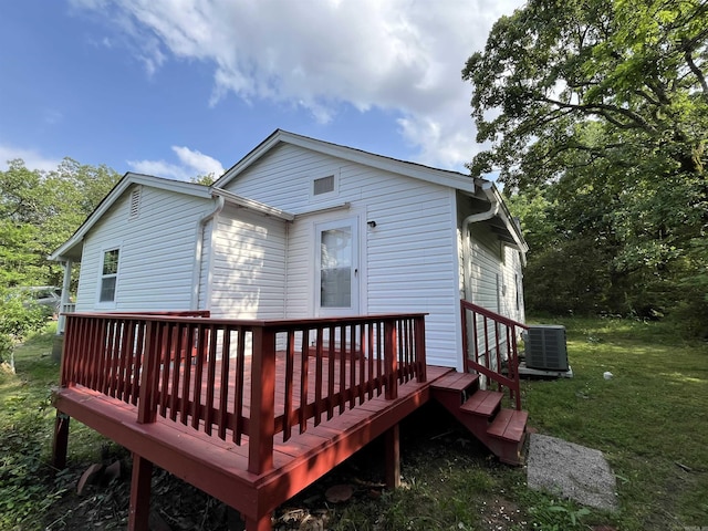 back of house with central AC, a deck, and a lawn