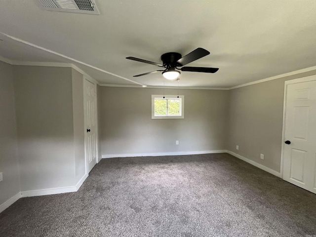 empty room with dark carpet, ceiling fan, and crown molding