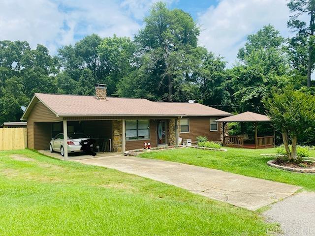 ranch-style house with a carport and a front lawn