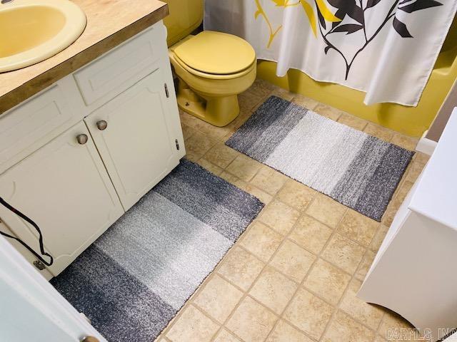 bathroom featuring walk in shower, vanity, toilet, and tile patterned floors