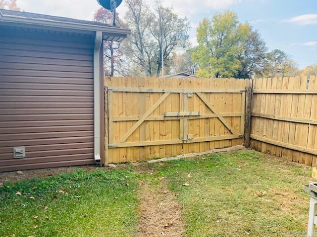 view of gate with a yard