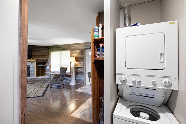 170 Ridge Rd, Houston, AR 72720 - laundry area with wood-type flooring, stacked washer and dryer, log walls, and laundry area