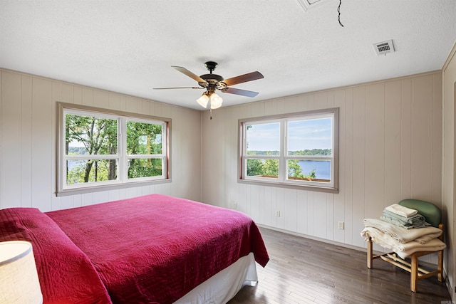 170 Ridge Rd, Houston, AR 72720 - bedroom with a water view, multiple windows, hardwood / wood-style flooring, and a textured ceiling