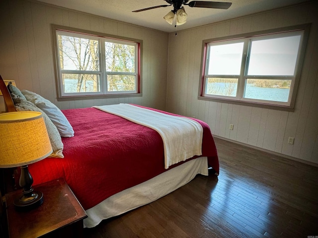 bedroom with dark hardwood / wood-style floors and ceiling fan