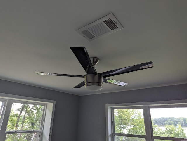 interior details featuring crown molding and ceiling fan