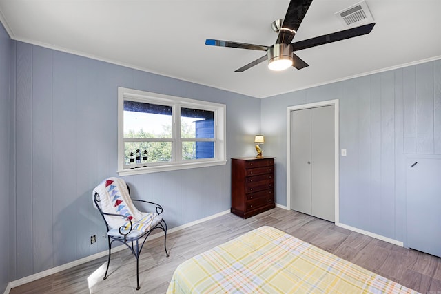 bedroom with a closet, ceiling fan, light wood-type flooring, and crown molding