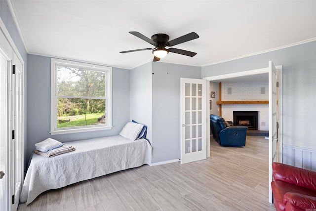 bedroom featuring ceiling fan, ornamental molding, and a fireplace