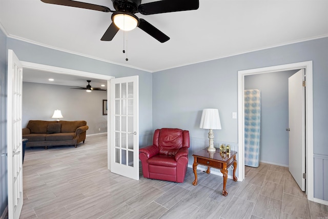 living area featuring ceiling fan, french doors, and crown molding