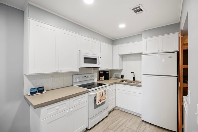 kitchen with white appliances, sink, tasteful backsplash, and white cabinetry