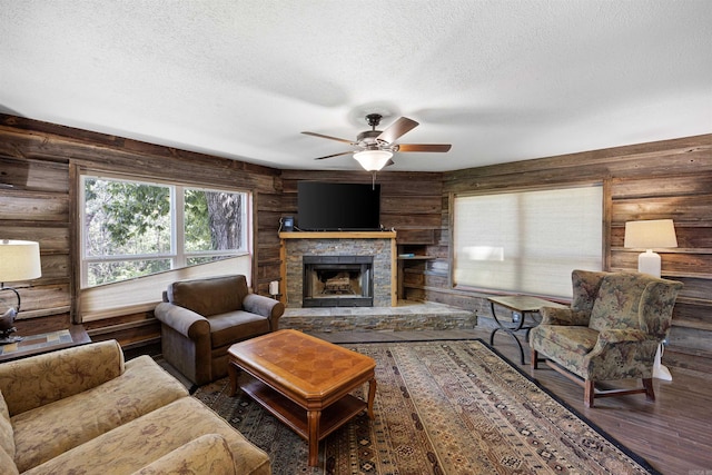 170 Ridge Rd, Houston, AR 72720 - living room featuring a stone fireplace, a ceiling fan, a textured ceiling, and wood finished floors