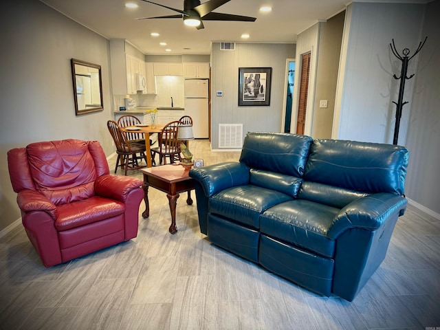 living room featuring ceiling fan and sink