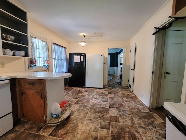 kitchen with black fridge, ornamental molding, range, and kitchen peninsula