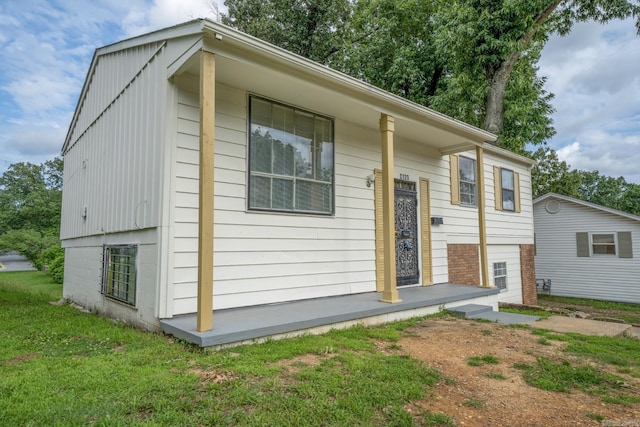 exterior space with covered porch and a yard