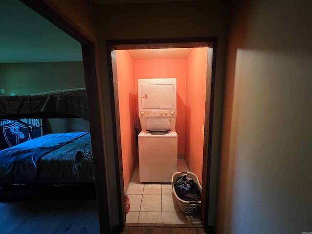 hall featuring light tile patterned floors and stacked washer / dryer