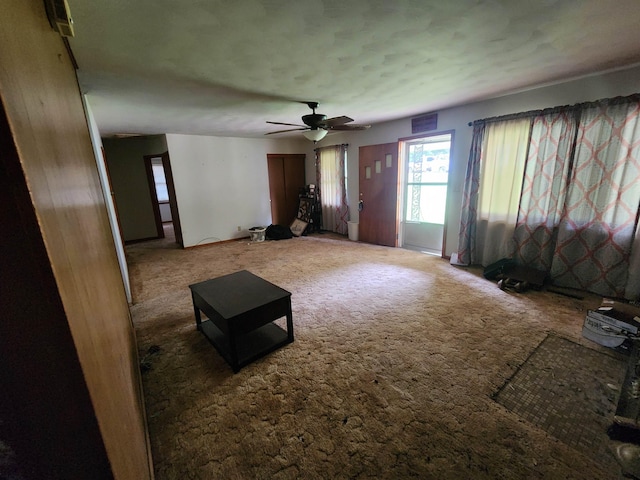 unfurnished living room featuring carpet flooring and ceiling fan