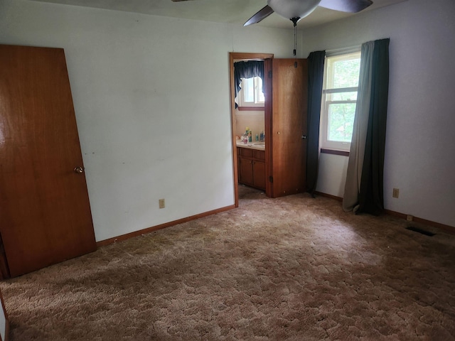 carpeted spare room featuring ceiling fan