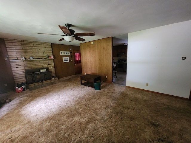 unfurnished living room featuring wood walls, carpet floors, and ceiling fan