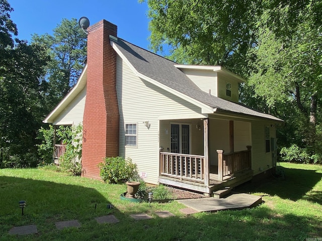 rear view of property with a porch and a lawn