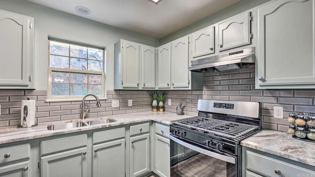 kitchen with white cabinets, gas range, backsplash, and sink