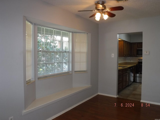 unfurnished dining area with a textured ceiling, ceiling fan, dark hardwood / wood-style flooring, and sink