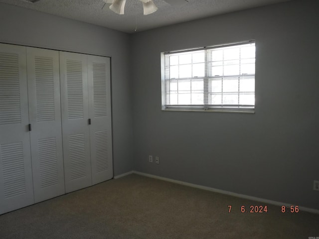 unfurnished bedroom featuring carpet flooring, ceiling fan, a closet, and a textured ceiling