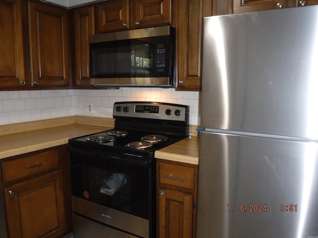 kitchen with tasteful backsplash and appliances with stainless steel finishes