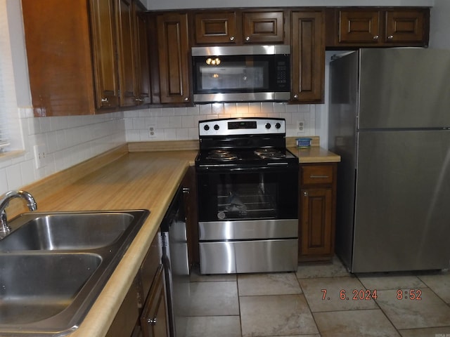 kitchen with sink, stainless steel appliances, wood counters, tasteful backsplash, and light tile patterned floors