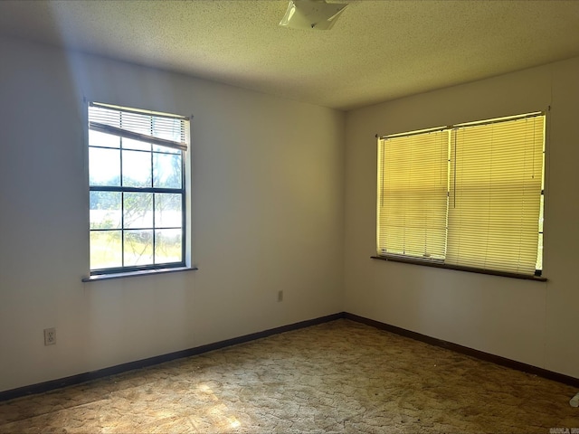 unfurnished room featuring a textured ceiling