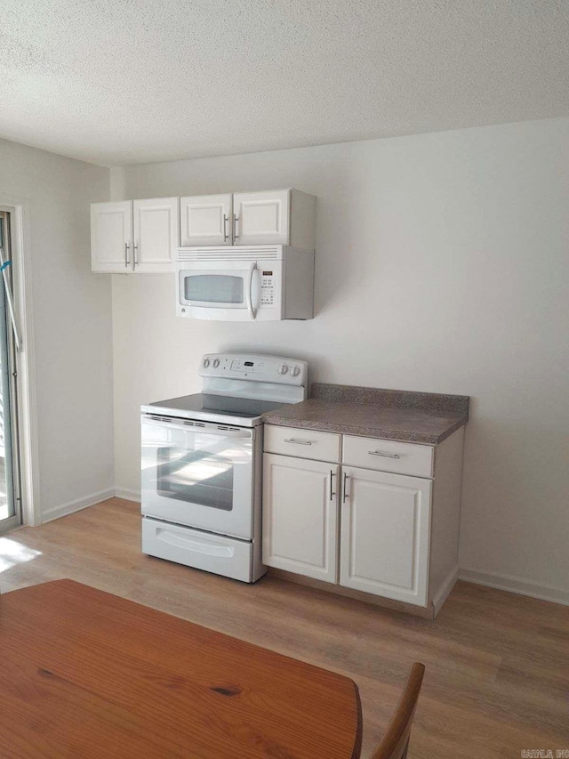 kitchen featuring light hardwood / wood-style flooring, white cabinets, and white appliances