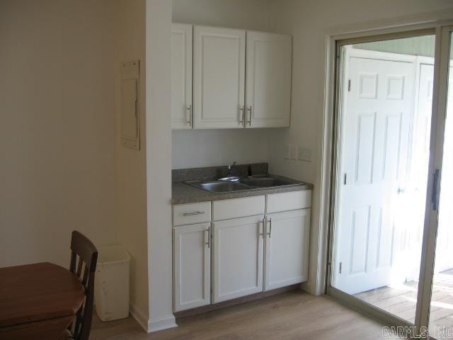 kitchen with sink, white cabinets, and light hardwood / wood-style floors