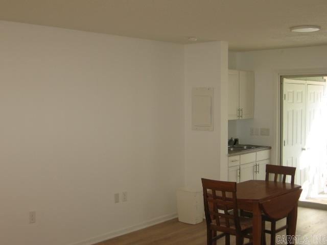 dining space featuring light wood-type flooring and sink