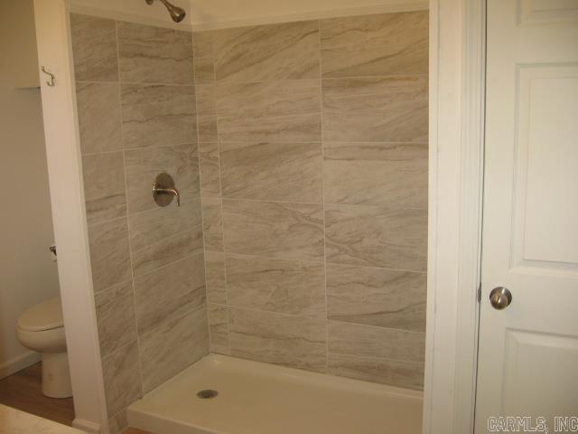 bathroom featuring toilet and tiled shower