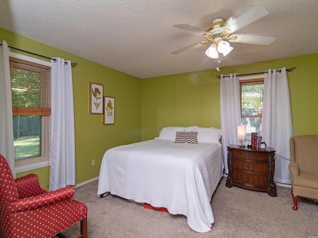 carpeted bedroom featuring a textured ceiling and ceiling fan