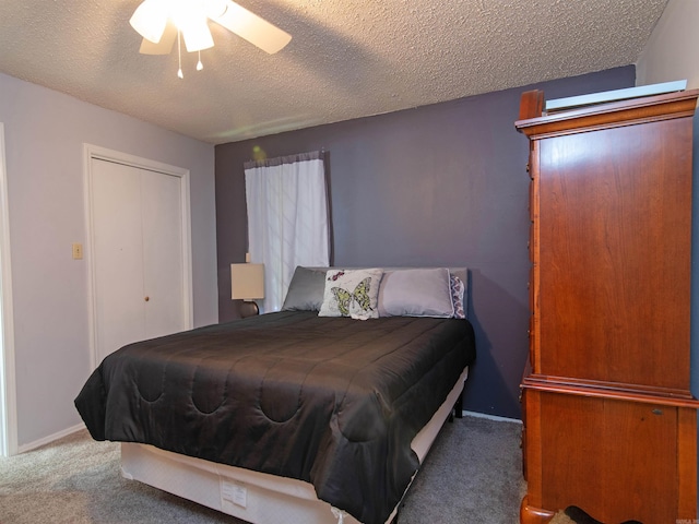 bedroom with ceiling fan, dark carpet, a textured ceiling, and a closet