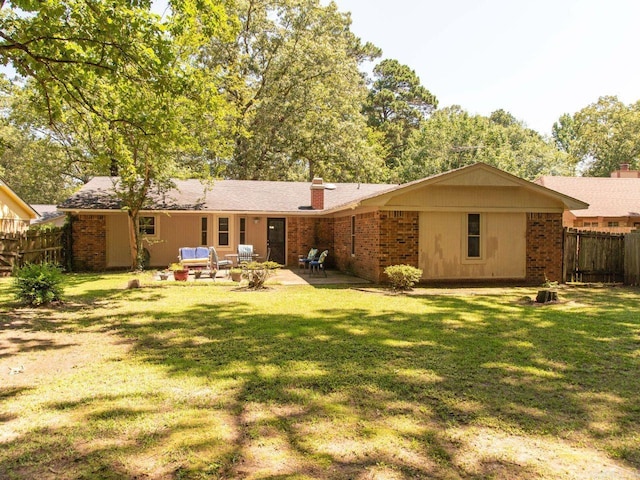 back of property with a lawn, an outdoor living space, and a patio