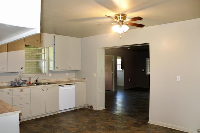 kitchen featuring white cabinets, white dishwasher, light countertops, and a sink