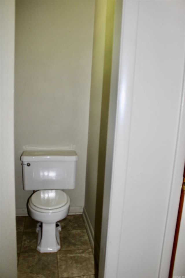 bathroom featuring tile patterned flooring, toilet, and baseboards