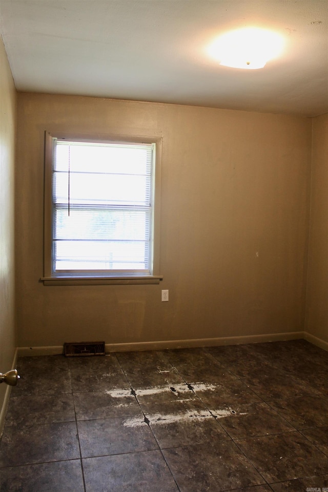 unfurnished room featuring visible vents and baseboards