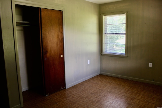 unfurnished bedroom with a closet and baseboards